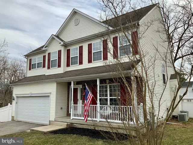 a view of a white house with large windows and a small yard