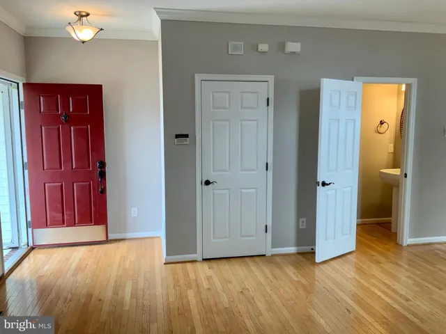 an empty room with wooden floor and closet area