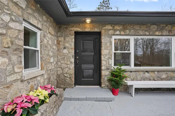 a front view of a house with outdoor seating and flowers
