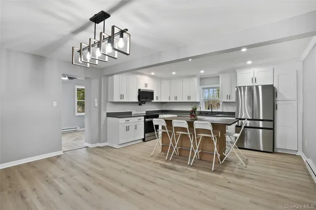 a view of a dining room with furniture a kitchen and chandelier