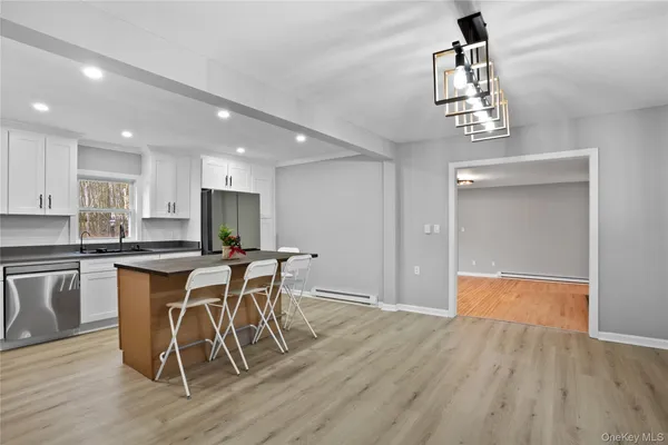 a kitchen with stainless steel appliances granite countertop a kitchen island a stove a cabinets a sink and a refrigerator