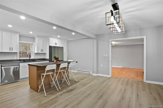 a kitchen with stainless steel appliances granite countertop a kitchen island a stove a cabinets a sink and a refrigerator