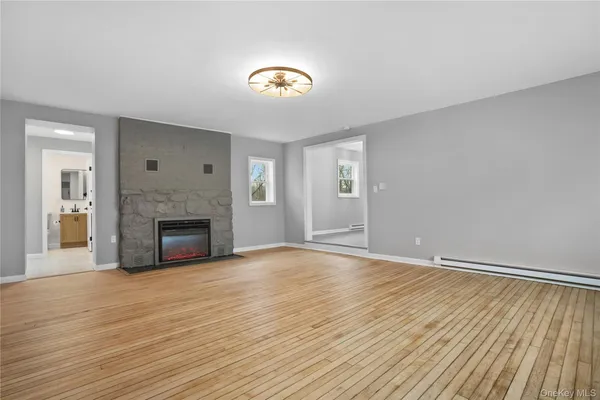a view of empty room with wooden floor and fireplace
