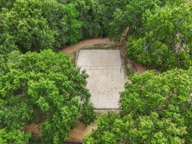 an aerial view of a house with a yard and large trees