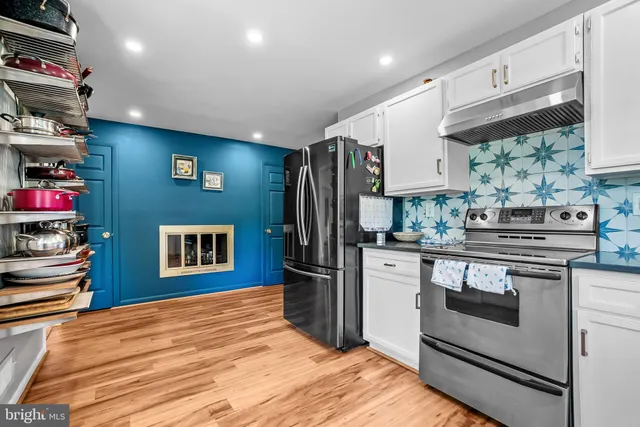 a kitchen with stainless steel appliances granite countertop a refrigerator and a stove