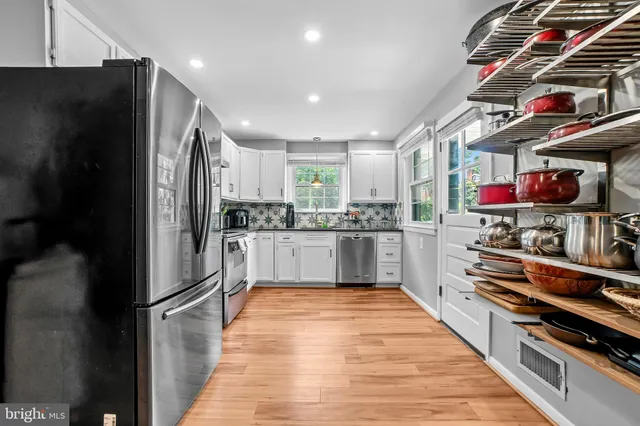 a kitchen with stainless steel appliances granite countertop a refrigerator and a stove