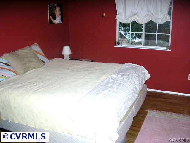 10512 White Rabbit Road Richmond, VA 23235 - Photo 6 of 10 a bed sitting in a bedroom next to a window