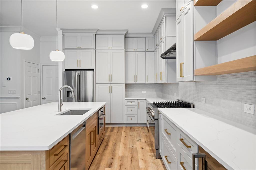 3628 Ashcroft Bend Atlanta, GA 30319 - Photo 11 of 44 a kitchen with a sink dishwasher and white cabinets with wooden floor