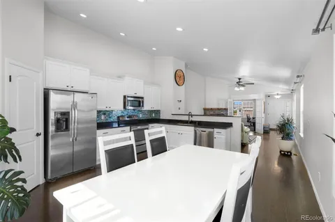 a kitchen with refrigerator and chairs