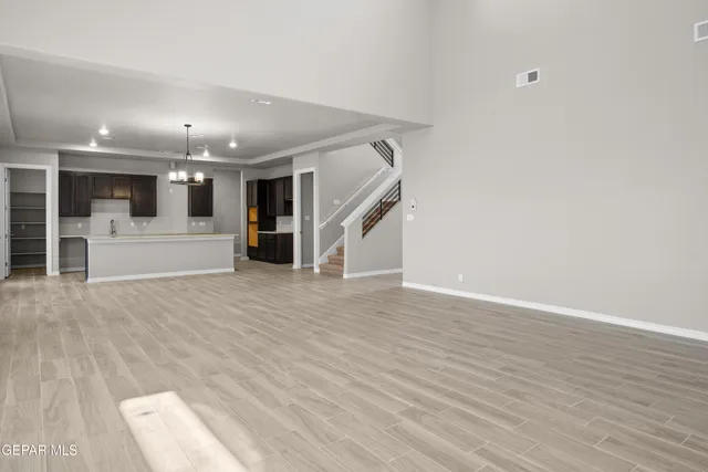 a view of a big room with wooden floor and windows