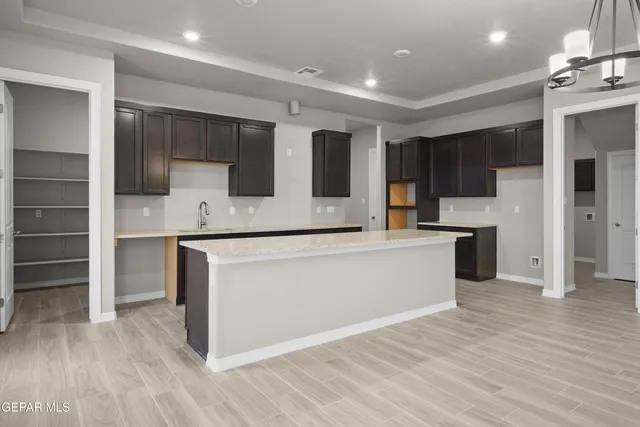 a large kitchen with stainless steel appliances a large counter top and a stove