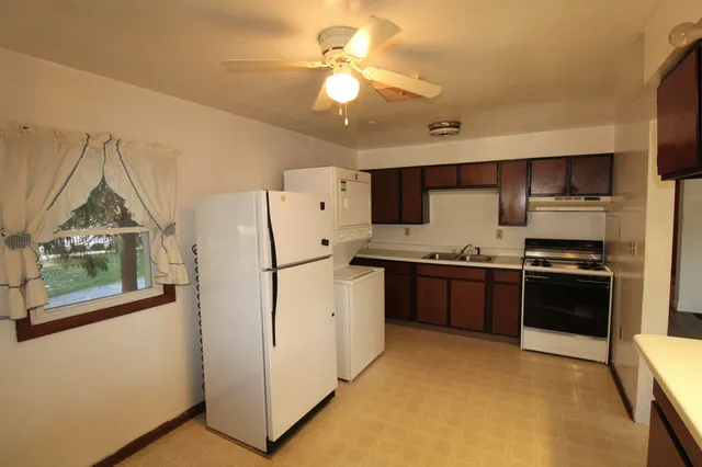 a kitchen with refrigerator cabinets and stove top oven