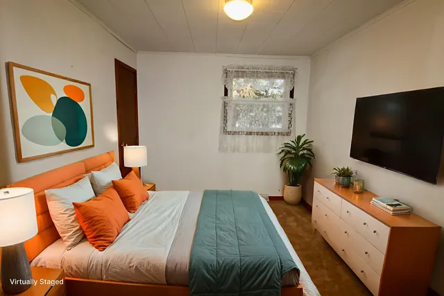 a bedroom with a bed and a flat screen tv