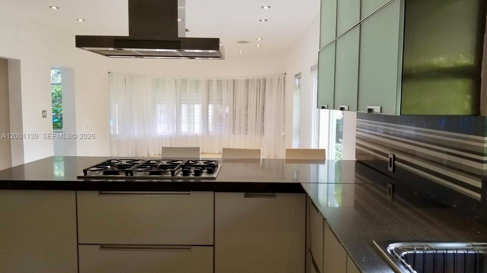 625 93rd Street Surfside, FL 33154 - Photo 11 of 50 a kitchen with a sink and a stove top oven