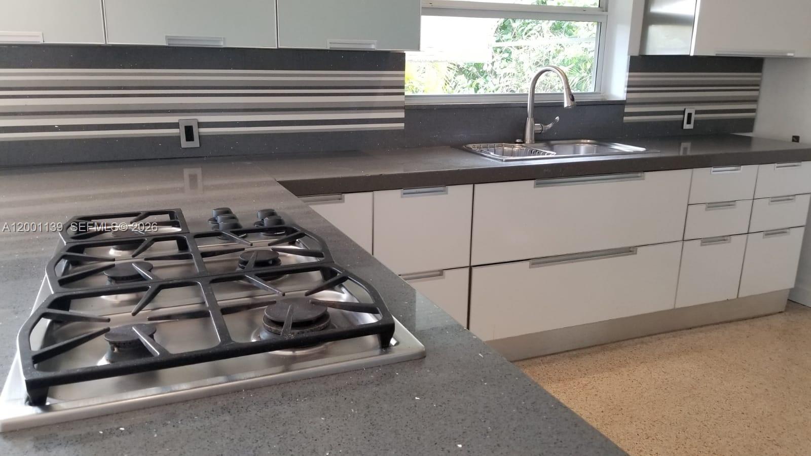 625 93rd Street Surfside, FL 33154 - Photo 13 of 50 a kitchen with a stove and a sink