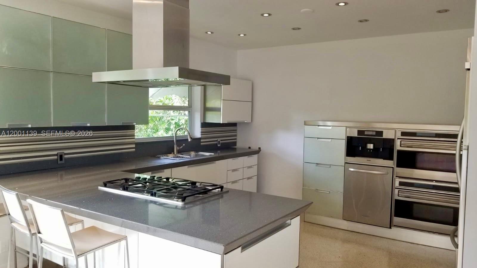 625 93rd Street Surfside, FL 33154 - Photo 14 of 50 a kitchen with a stove a sink and a refrigerator
