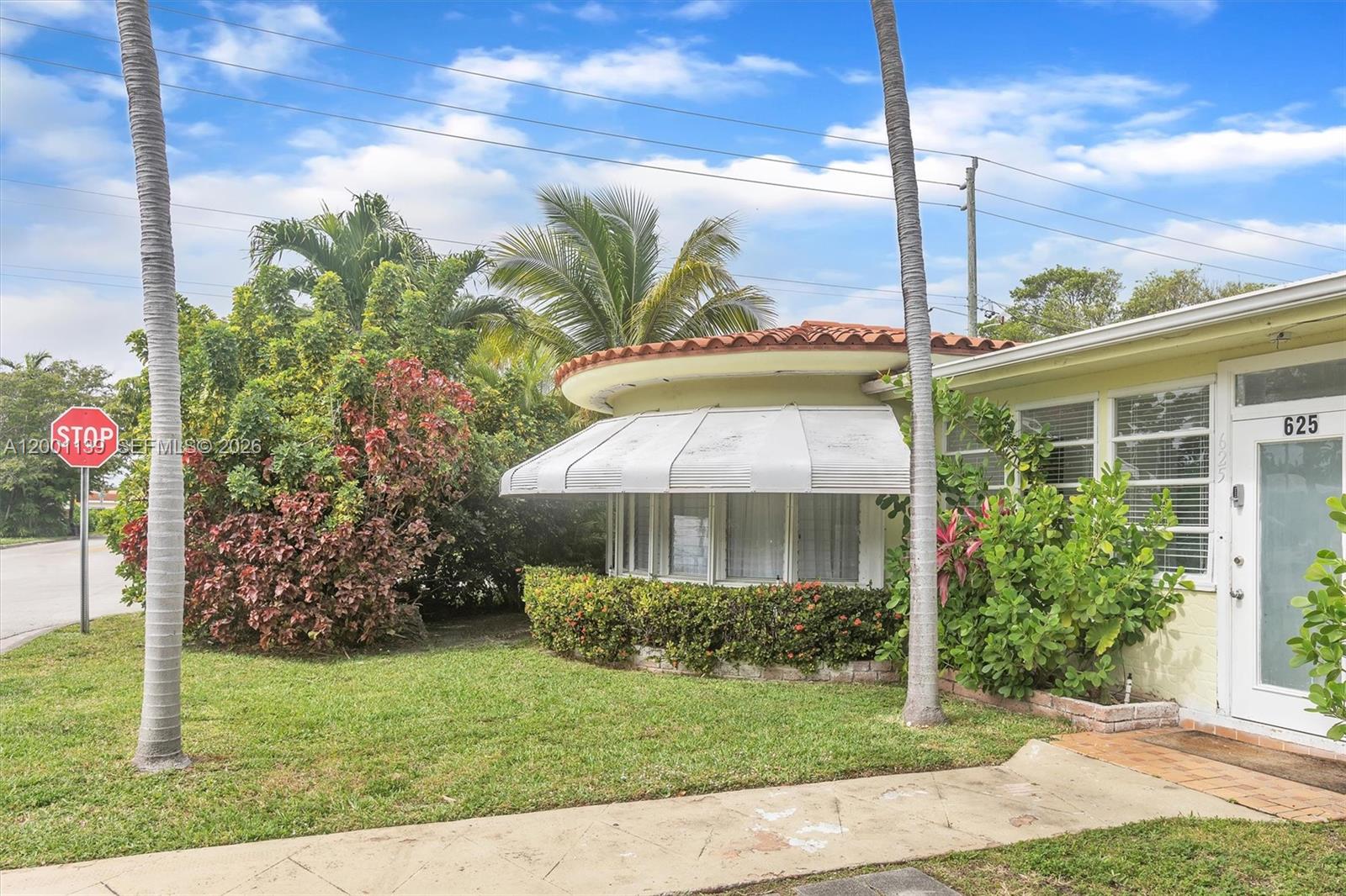 625 93rd Street Surfside, FL 33154 - Photo 6 of 50 a front view of a house with a yard and potted plants