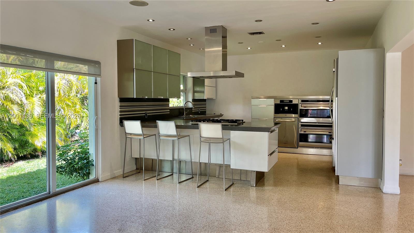 625 93rd Street Surfside, FL 33154 - Photo 10 of 50 a kitchen with granite countertop a stove a sink a refrigerator and a dining table
