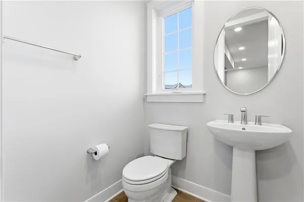 a bathroom with a toilet a sink and mirror