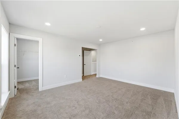 an empty room with closet and a bathroom