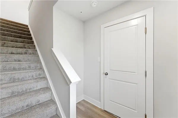a view of staircase with wooden floor and white walls