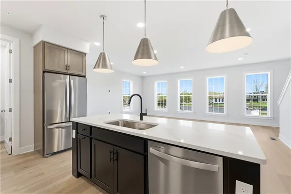 a kitchen with stainless steel appliances granite countertop a sink a refrigerator and a stove