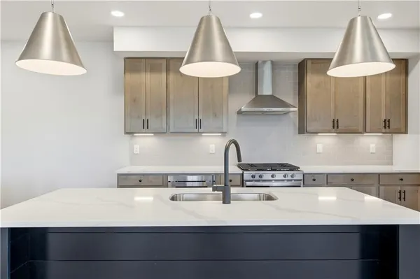 a kitchen with stainless steel appliances a stove a sink and a white cabinets