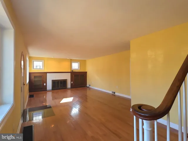 an empty room with windows and a fireplace