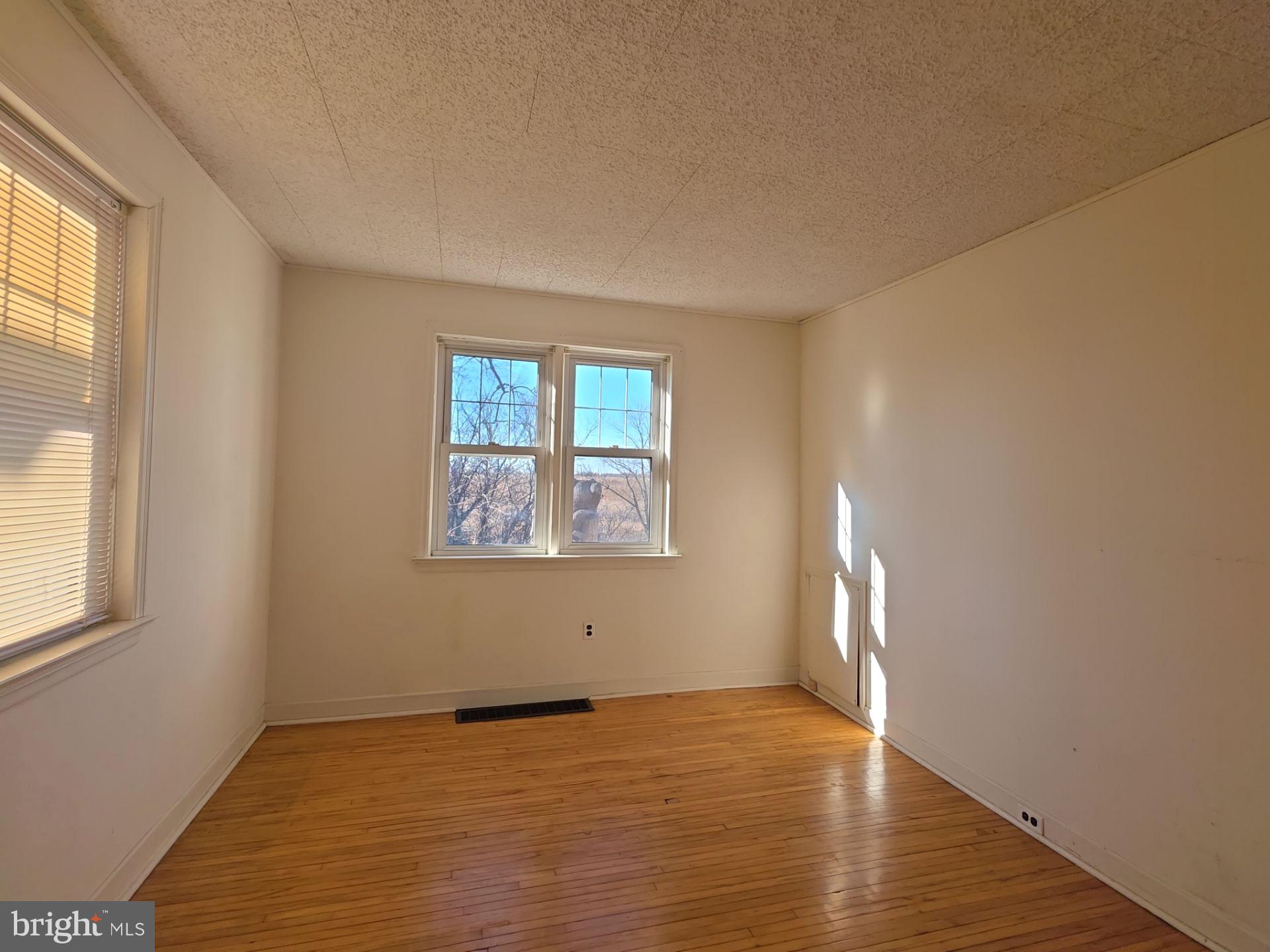 167 Singley Avenue Runnemede, NJ 08078 - Photo 26 of 56 an empty room with wooden floor and windows