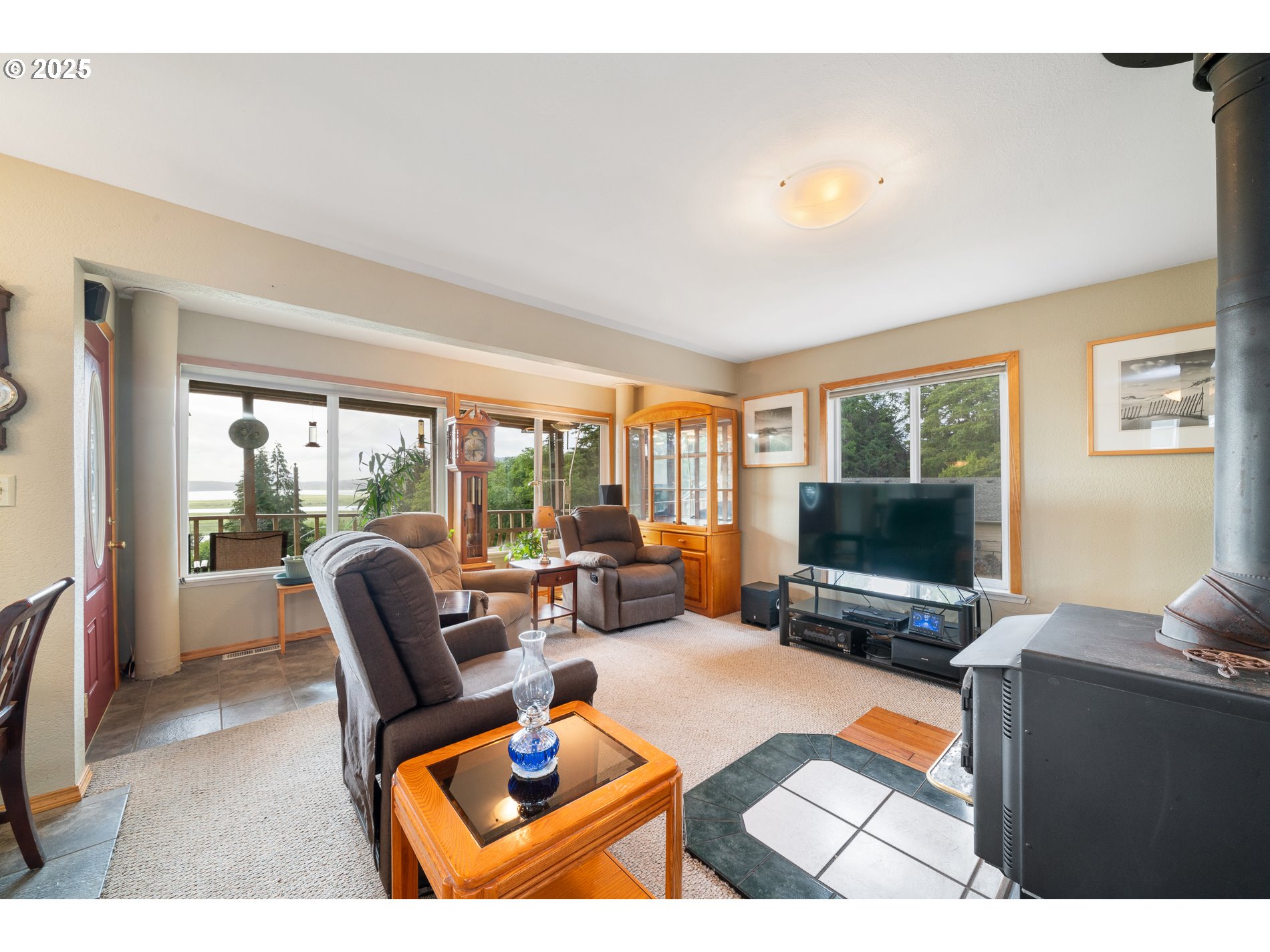 336 Gregory Street Wheeler, OR 97147 - Photo 14 of 42 a living room with furniture a flat screen tv and a floor to ceiling window