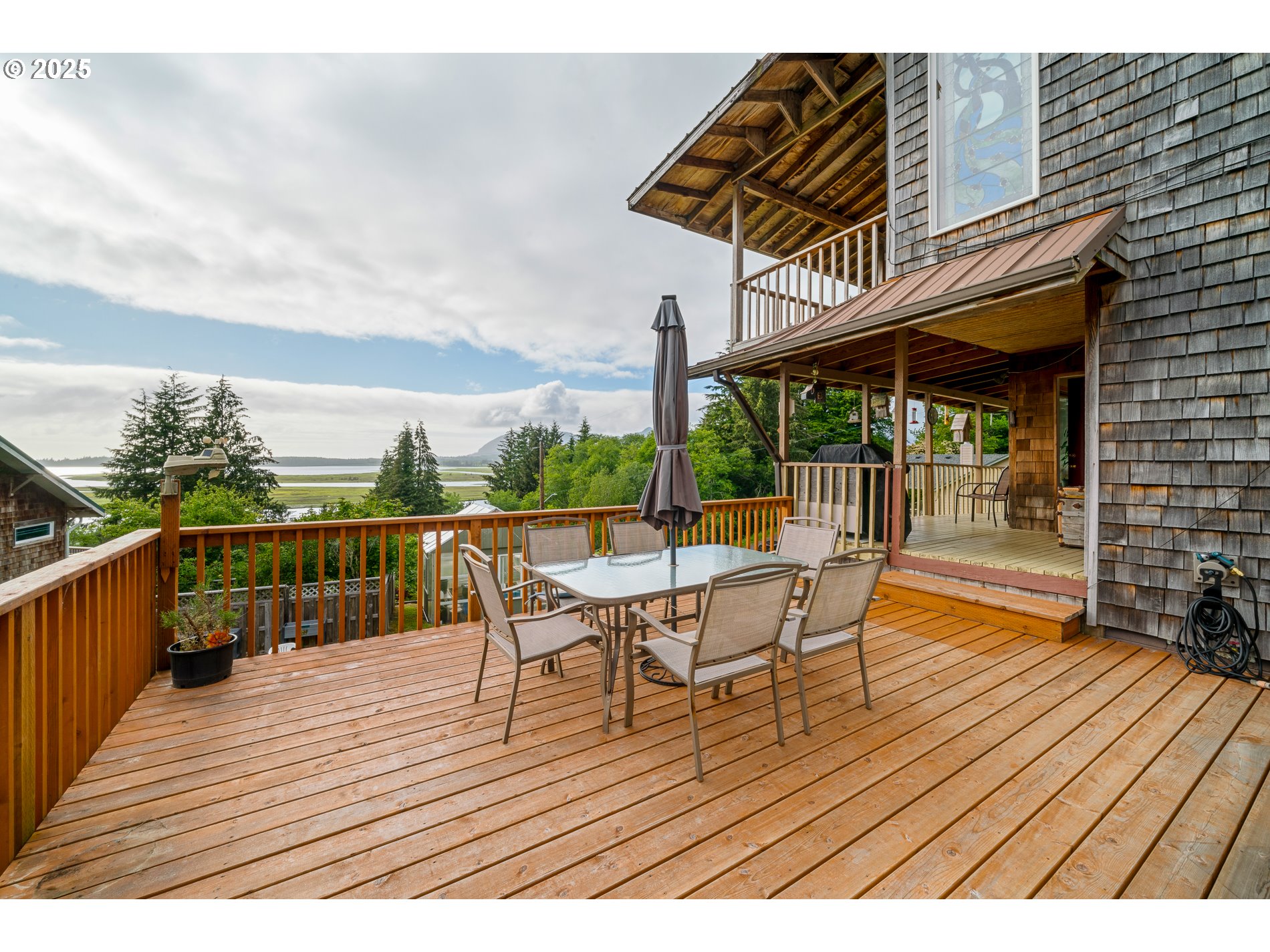 336 Gregory Street Wheeler, OR 97147 - Photo 4 of 42 a view of a roof deck with table and chairs a barbeque with wooden floor