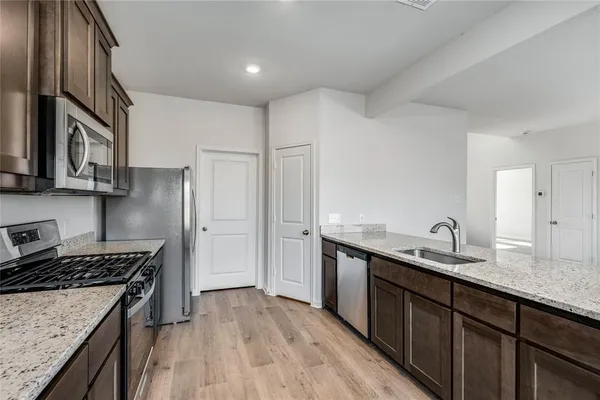 a kitchen with stainless steel appliances granite countertop a sink stove and refrigerator