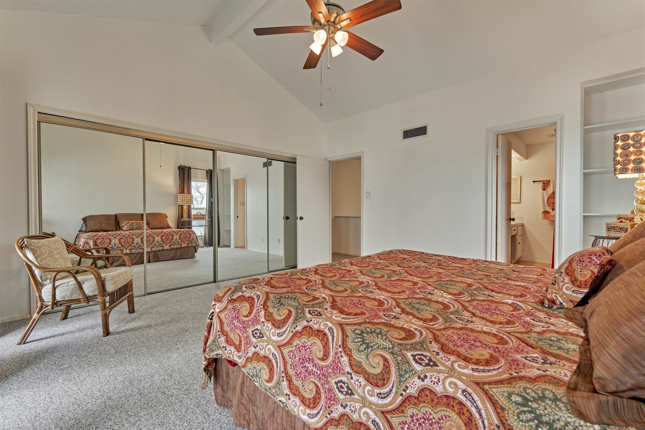 1427 Bowsprit Point Willis, TX 77318 - Photo 33 of 47 The vaulted ceiling makes for a grand and airy feel. A wall of sliding glass doors hides a closet with built-ins. An ensuite bath completes this primary bedroom.
