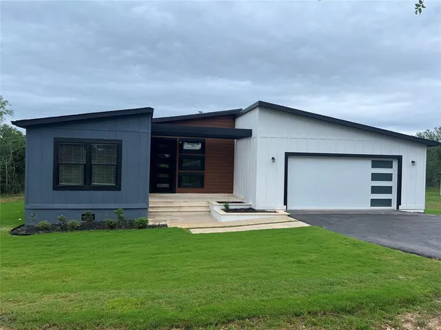 a living room with furniture a flat screen tv and kitchen view