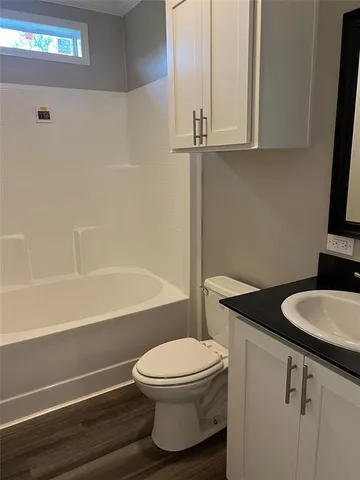 a view of an empty room with wooden floor and closet