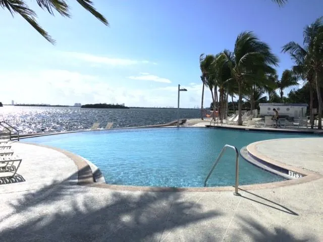 a view of a swimming pool with a lawn chairs under an umbrella