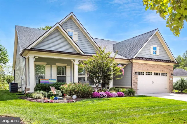 a front view of a house with a yard and potted plants