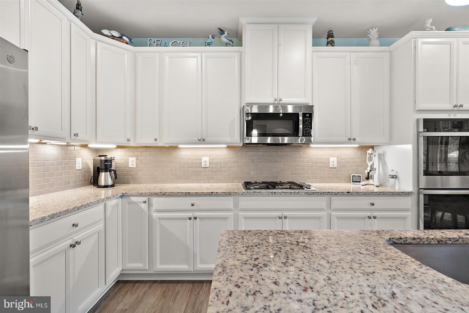 23546 Robalo Road Frankford, DE 19945 - Photo 27 of 78 a kitchen with stainless steel appliances granite countertop a sink a stove and cabinets