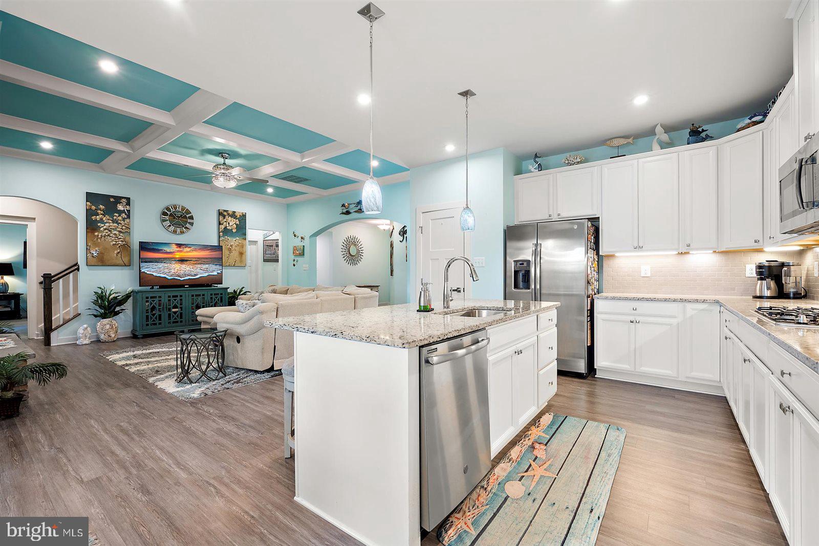 23546 Robalo Road Frankford, DE 19945 - Photo 30 of 78 a kitchen with stainless steel appliances granite countertop a refrigerator a stove a sink dishwasher and a refrigerator with wooden floor