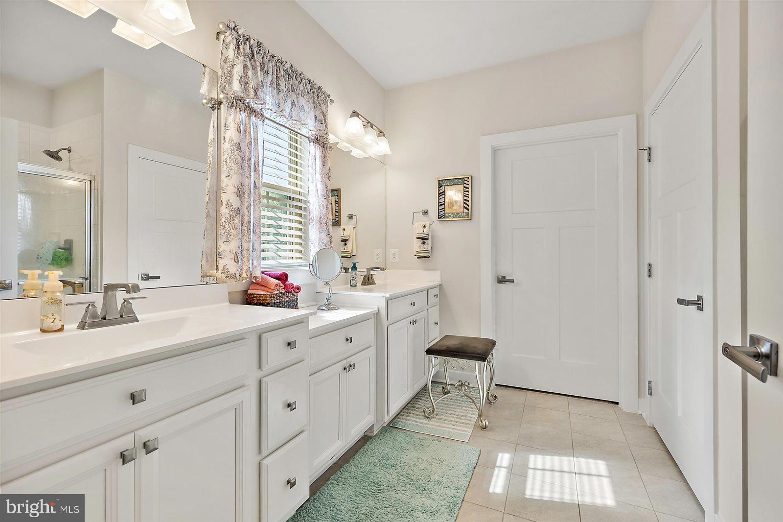 23546 Robalo Road Frankford, DE 19945 - Photo 39 of 78 a spacious bathroom with a double vanity sink a mirror and a shower