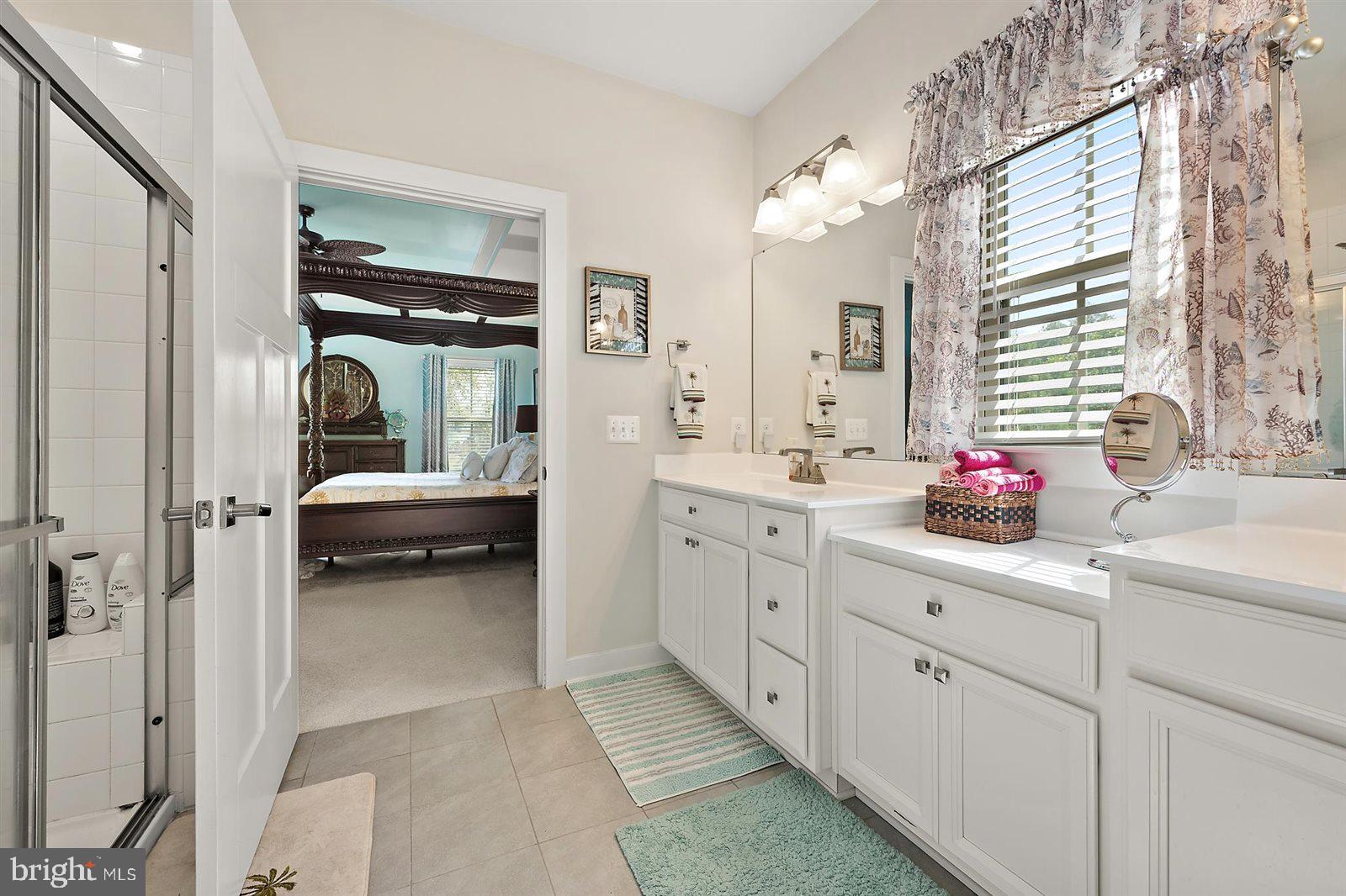 23546 Robalo Road Frankford, DE 19945 - Photo 41 of 78 a en suite bathroom with a double vanity sink a mirror and next to a window