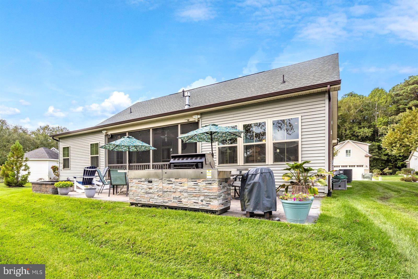 23546 Robalo Road Frankford, DE 19945 - Photo 60 of 78 a view of a patio with table and chairs potted plants and floor to ceiling window