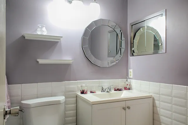 a bathroom with a toilet a sink and mirror