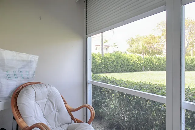 a outdoor room with a large window and chairs