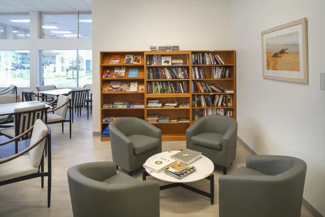 a living room with furniture a bookshelf and a window