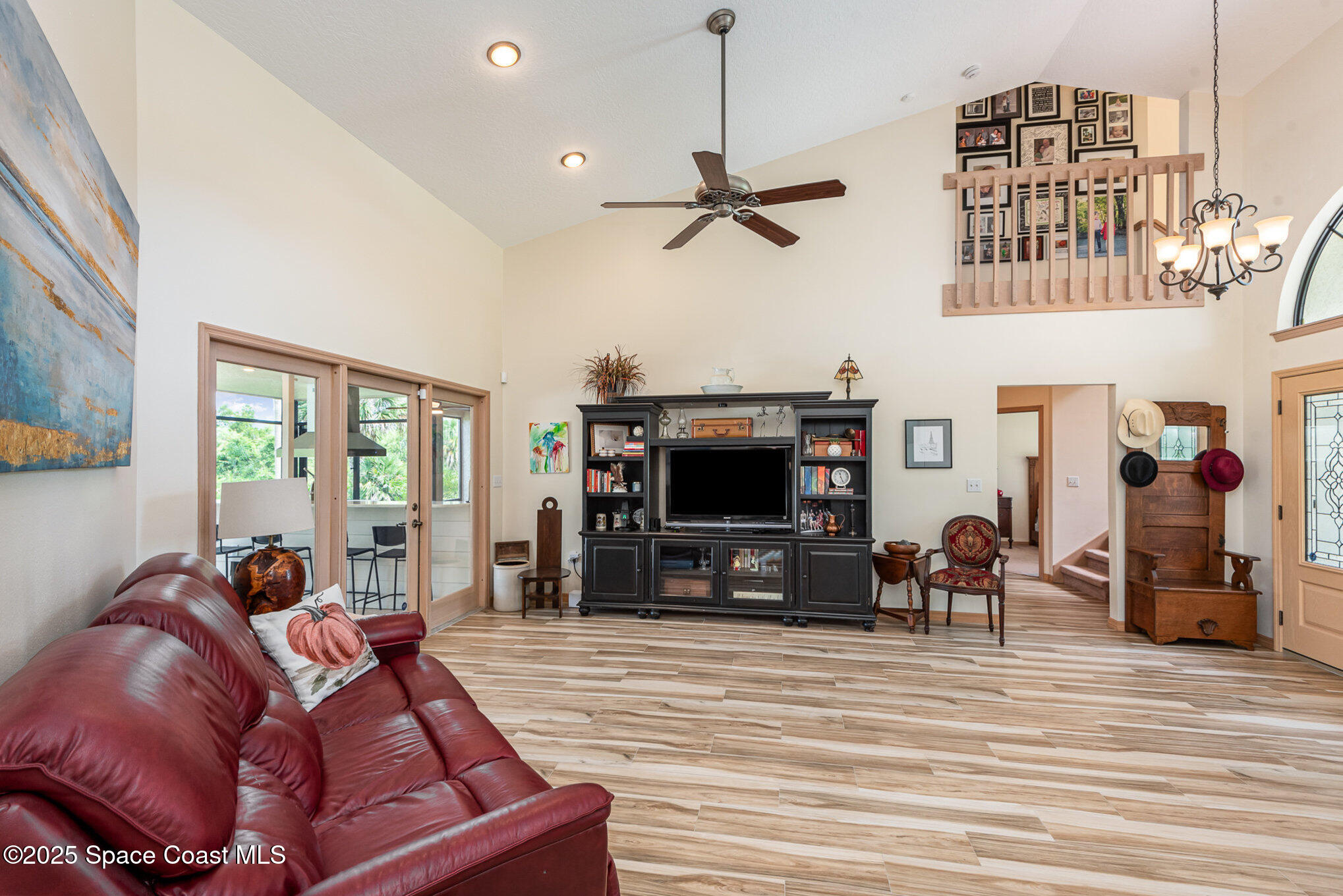 3750 Shady Run Road Melbourne, FL 32934 - Photo 12 of 50 a living room with furniture a flat screen tv and a fireplace