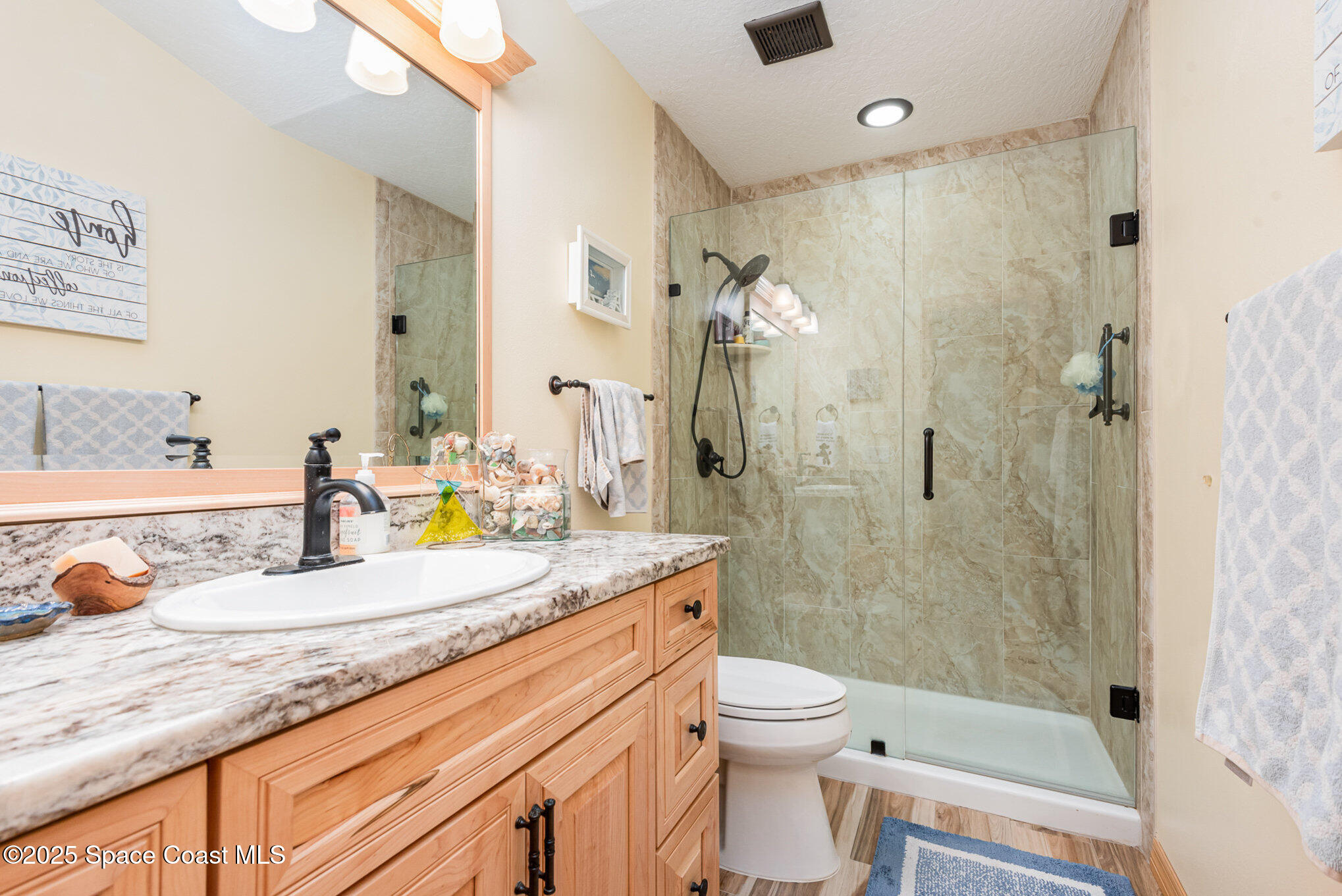 3750 Shady Run Road Melbourne, FL 32934 - Photo 27 of 50 a bathroom with a granite countertop sink a toilet and shower