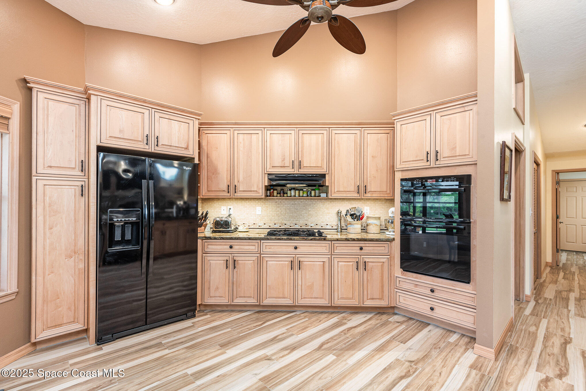 3750 Shady Run Road Melbourne, FL 32934 - Photo 7 of 50 a kitchen with stainless steel appliances granite countertop a refrigerator a oven a sink and white cabinets with wooden floor