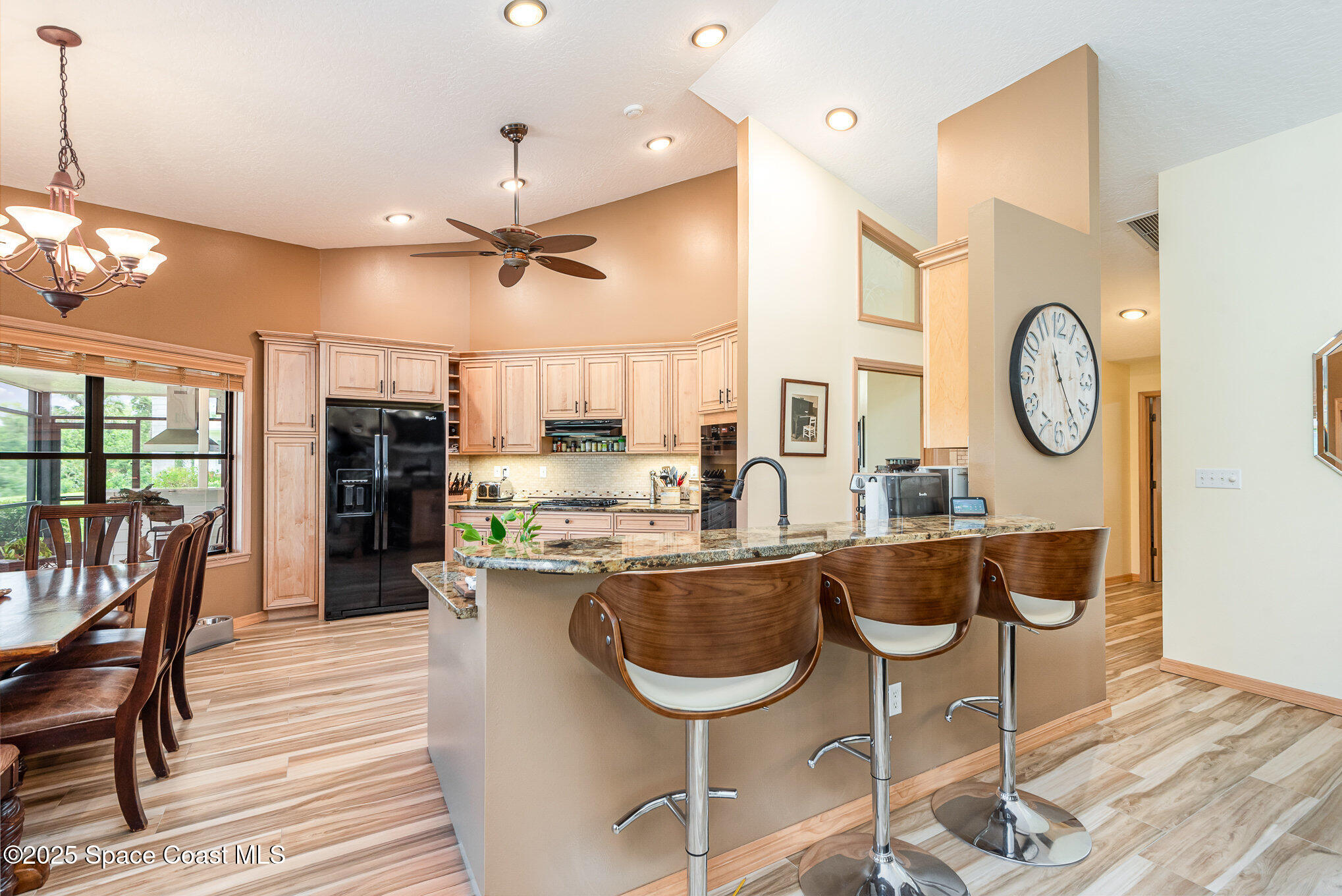 3750 Shady Run Road Melbourne, FL 32934 - Photo 9 of 50 a kitchen with stainless steel appliances granite countertop a stove a refrigerator a oven a dining table with white cabinets and wooden floor