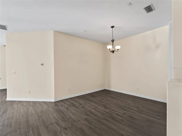 a view of a kitchen with a refrigerator wooden floor and a ceiling fan